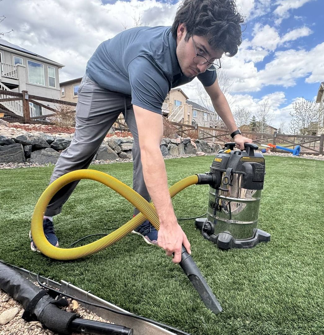 cleaning turf with a vacuum to prepare for repair